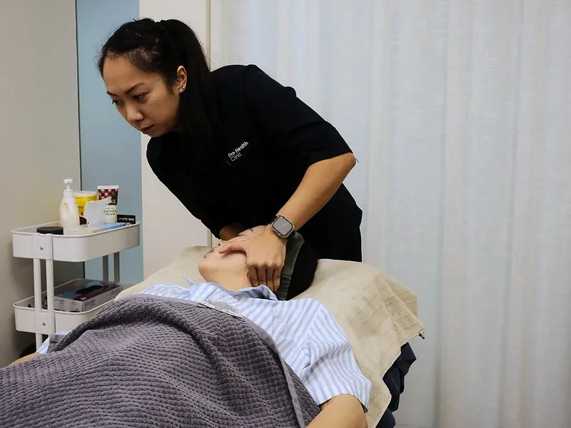 Practitioner positioning the laser therapy unit over the shoulder
